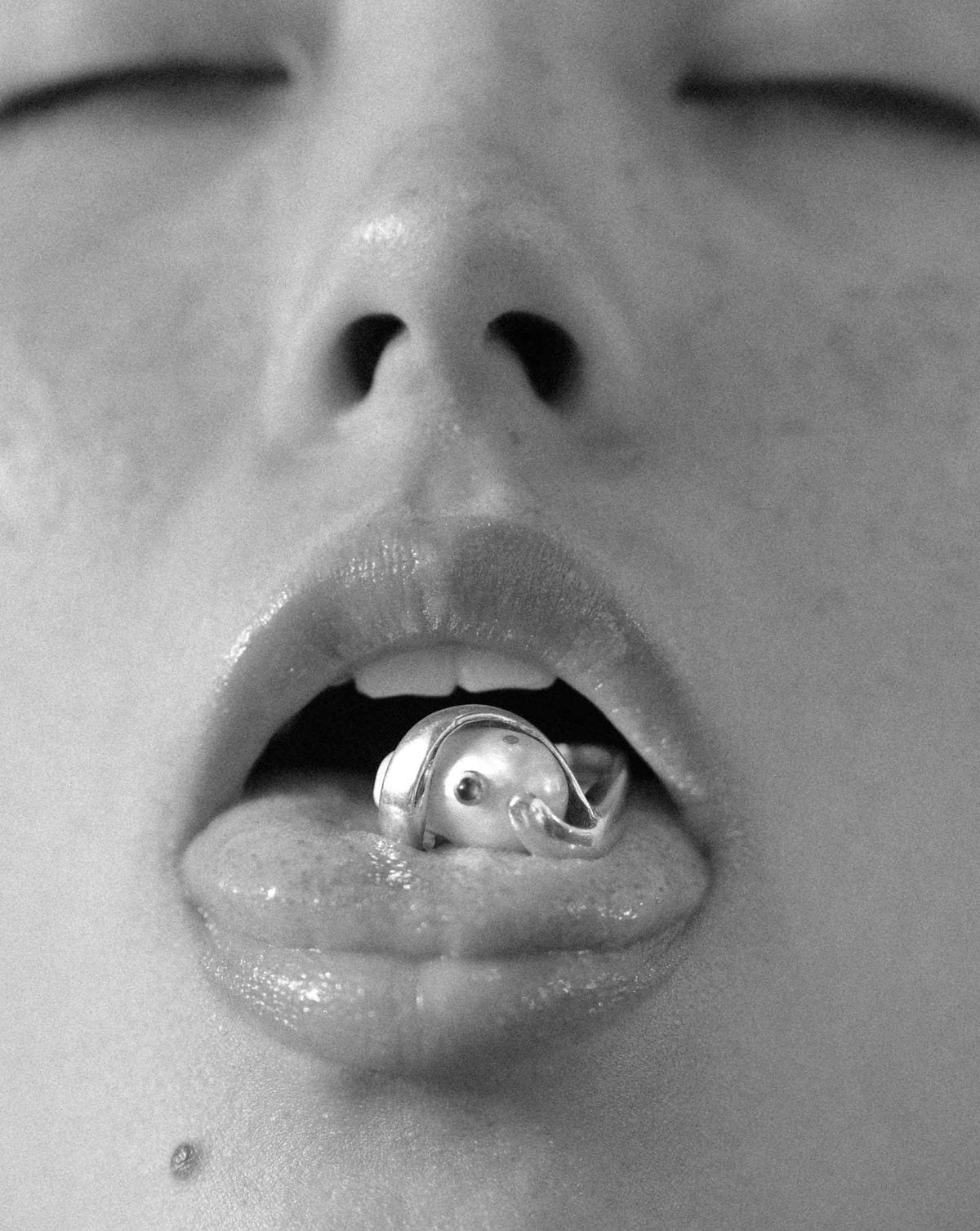 Pearl ring held between the lips
